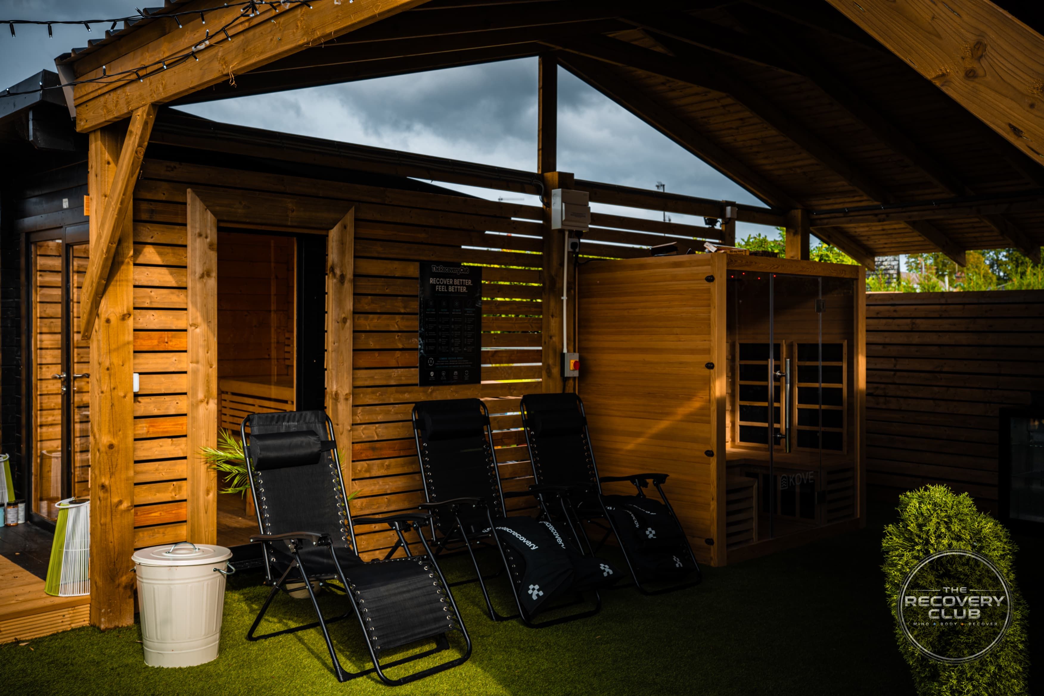 Three reclining chairs together beside the saunas in the club’s sheltered timber space.